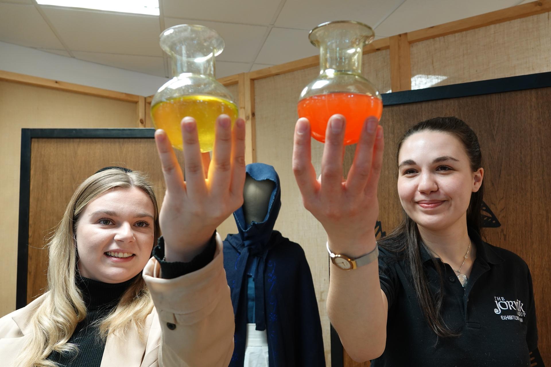 Harrogate BID Bethany Allen, Harrogate BID Business and Marketing Executive, left, and Sarah Checkland, The JORVIK Group of Attractions Exhibitions Manager, hold two uroscopy flasks which will feature in the Window on the Past pop-up museum