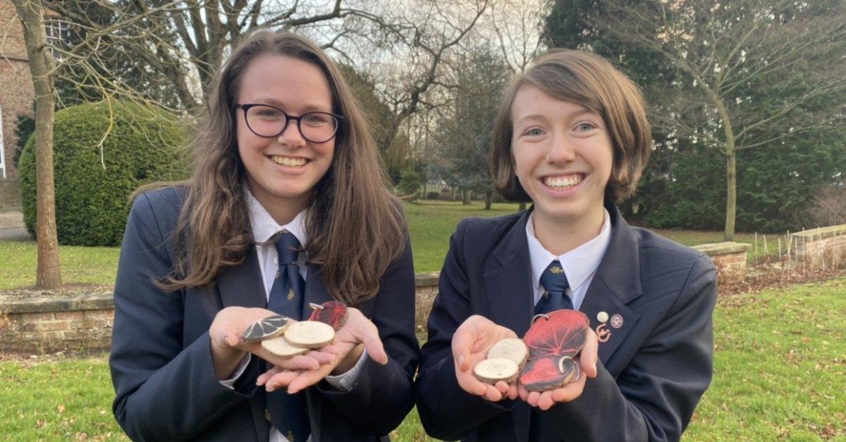 Ripon Grammar School sixth-formers Ellie Currass and Anna Bradley show off some the team's new keyrings, made from trees felled by winter storms.