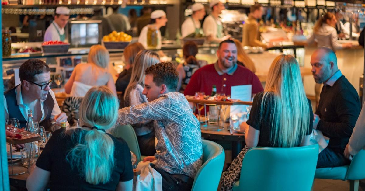 Seated customers laughing and chatting in a busy Piccolino Italian restaurant in Harrogate.