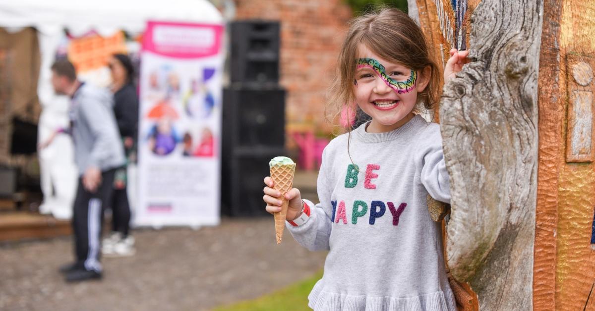 Photo of a little girl, wearing a 'Be Happy' top and eating an ice cream, at last year's BedFest event.