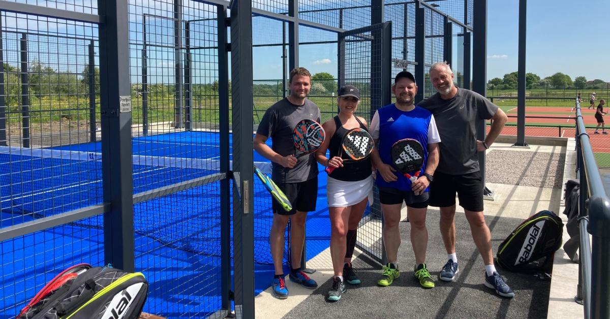 Photo of four players posing for the camera at the ate to one of the new padel courts at Harrogate Spa Tennis Club.