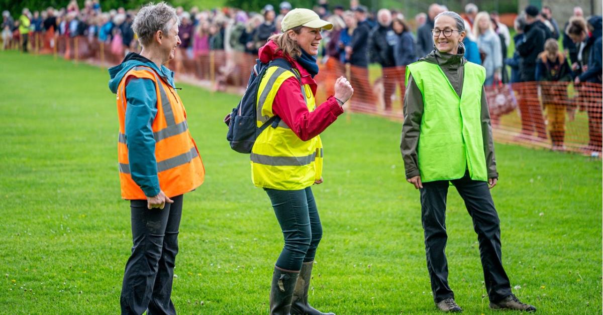 Photo of Masham Community Office volunteers Gaynor Pearson, Tessa Klemz, Amanda Horsell awaiting the result of the Cow Pat Competition.