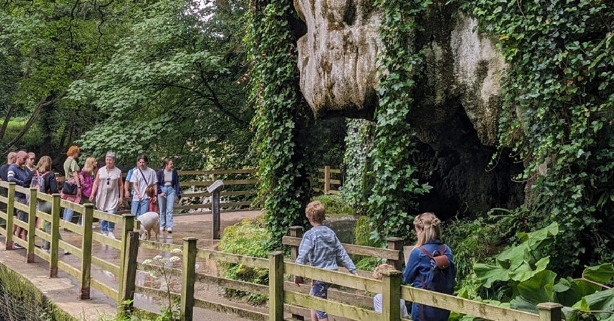 Photo of tourists walking past Mother Shipton's Cave in Knaresborough.