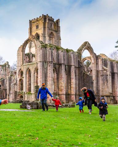 visitors-exploring-the-medieval-ruins-at-fountains-abbey-and-studley-royal-water-garden-north-yorkshire