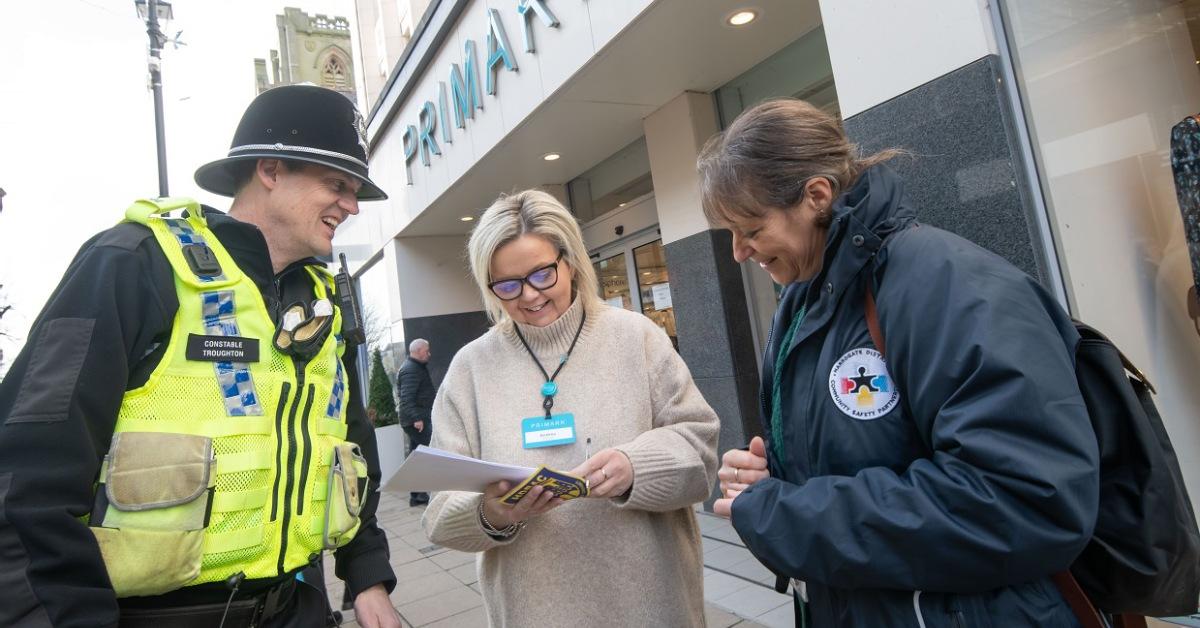 Photo of a police officer and someone from Harrogate District Community Safety Partnership talking to a store manager from Primark in Harrogate.