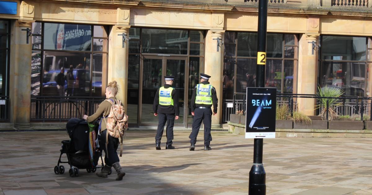 Photo of two North Yorkshire Police officers heading towards Victoria Shopping Centre while on patrol in Harrogate town centre.