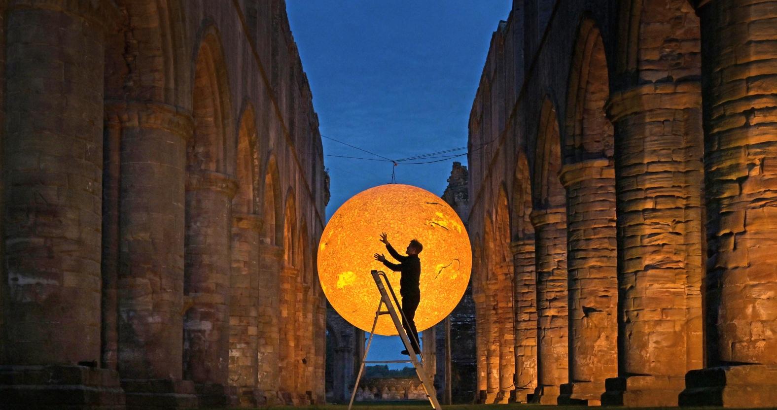 artist-luke-jerram-is-silhouetted-in-front-of-helios-at-fountains-abbey-credit-anthony-chappell-ross-1