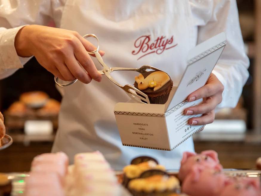 Bettys waiter boxing up one of their cakes