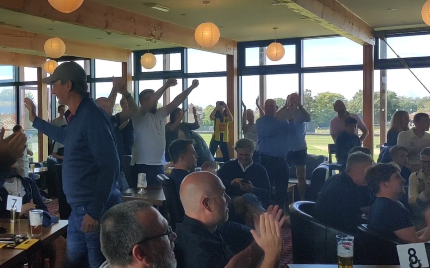 Harrogate Town fans at Harrogate Cricket Club celebrate the club's promotion.