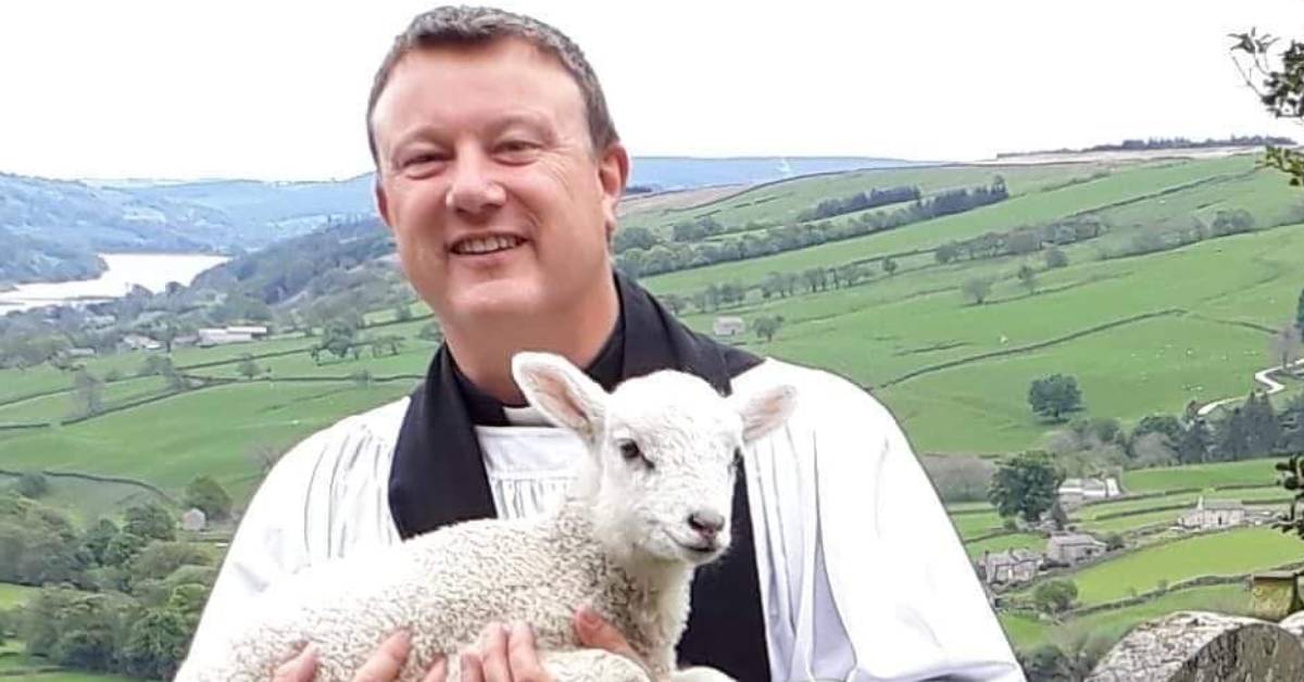 Photo of the Revd Darryl Hall with a spring lamb