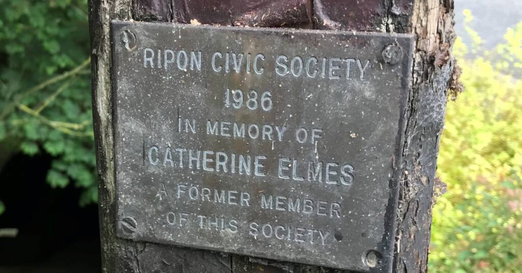 Photo of plaque on vandalised sign