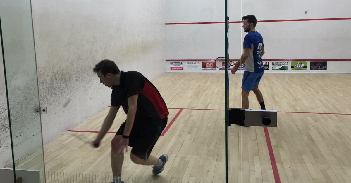 Declan playing in a squash match.